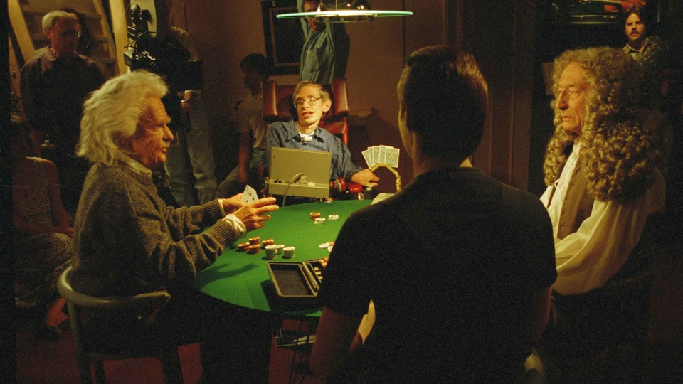 Stephen Hawking and actors dressed as Isaac Newton and Albert Einstein sit at a poker table surrounded by a film crew.