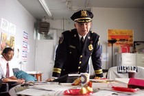 The cop character Stan Valchek standing over a desk in The Wire