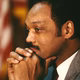 Color photograph of Jesse Jackson with his head resting on his hands.