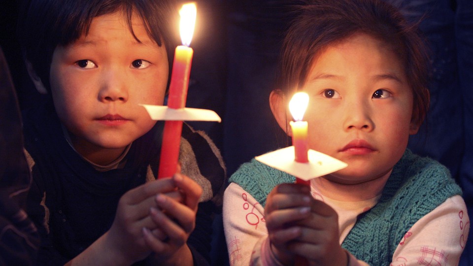 Children hold candles during the Easter mass at a church in Xiaohan village of Tianjin municipality in 2009.