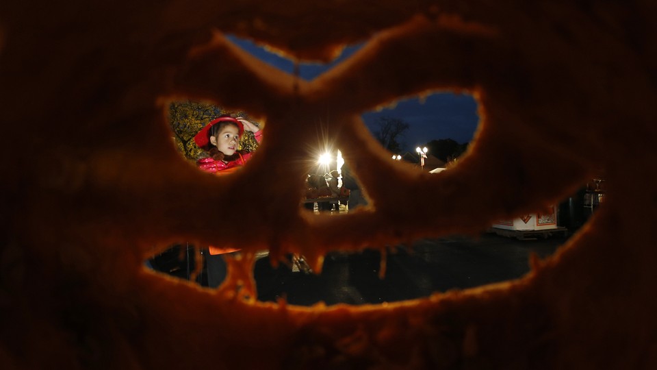 A girl is seen through one of the thousands of carved pumpkins at an Illinois pumpkin festival in 2013.