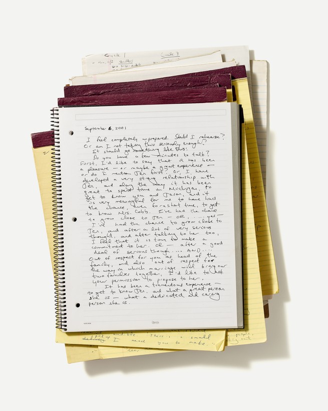 Photo of stack of legal pads with wire-bound notebook with diary entry on top