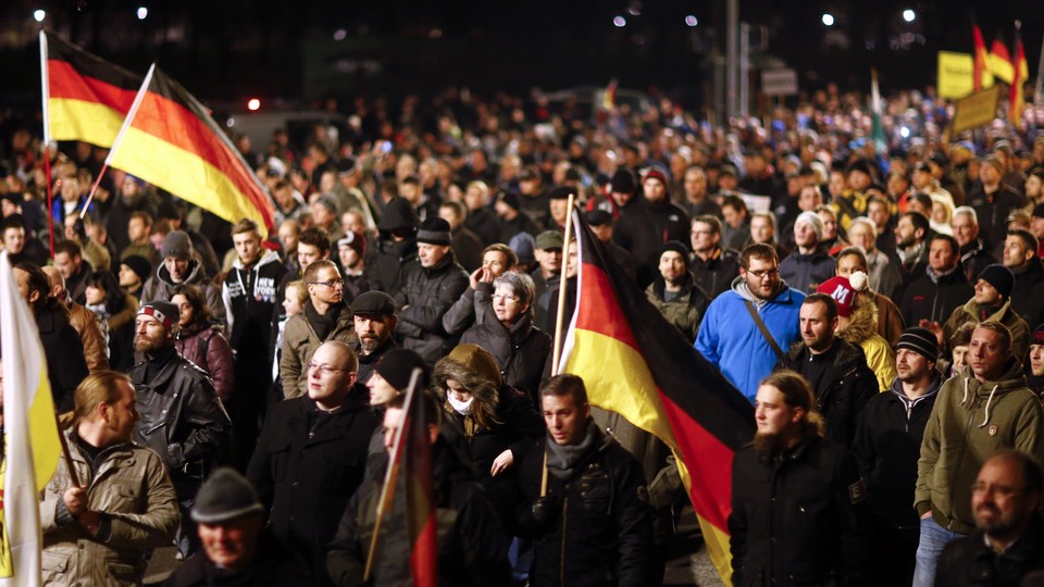 Participants hold German national flags during a demonstration called by anti-immigration group Pegida, a German abbreviation for "Patriotic Europeans against the Islamization of the West", in Dresden on December 15, 2014.