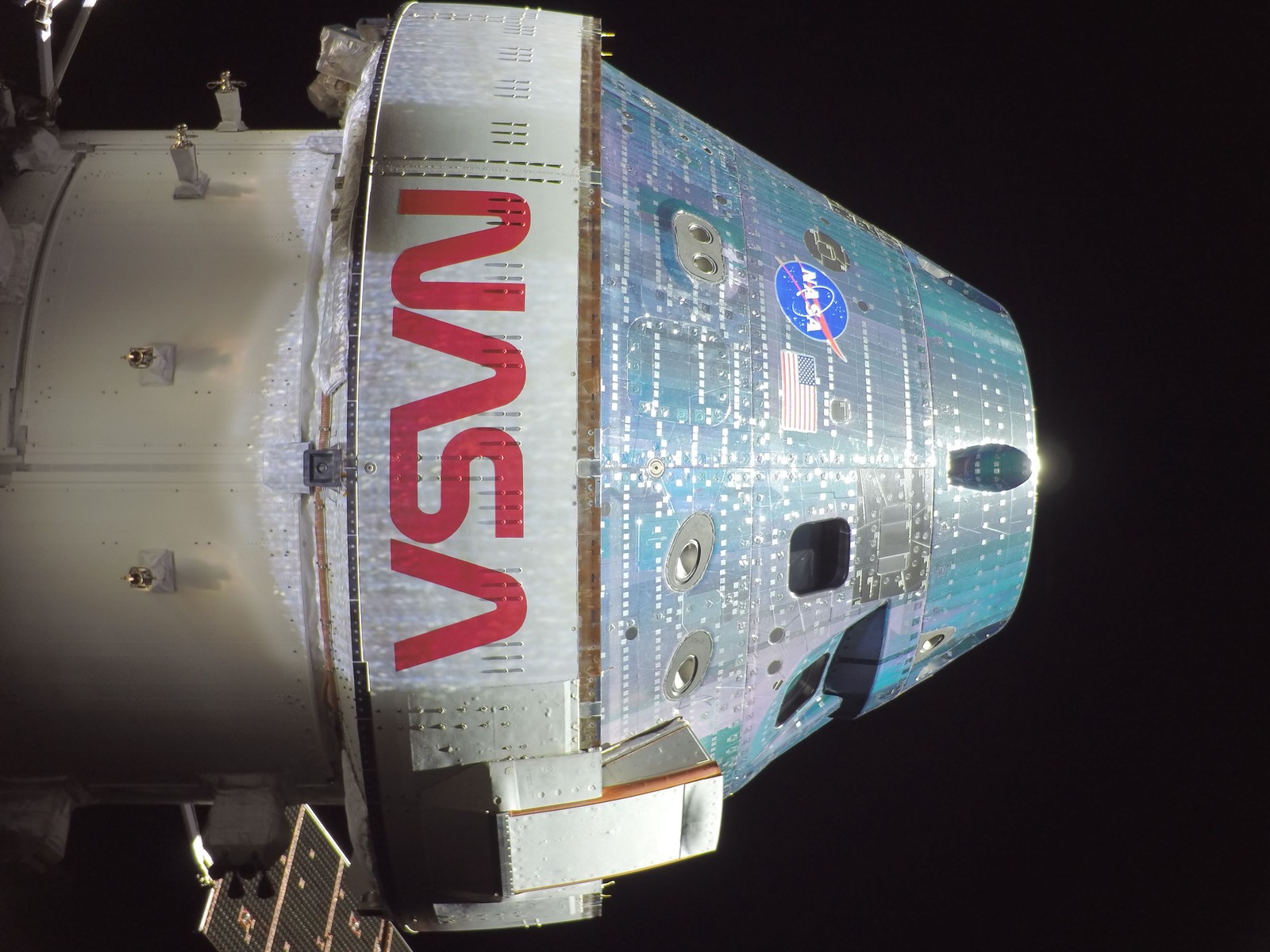 An external view of a space capsule, with the NASA logo written across the side