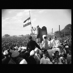 Jawaharlal Nehru addresses a crowd with the Indian flag at half-mast.