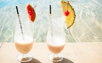 Photograph of two tropical drinks by the pool