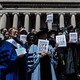 Photograph of a faculty protest at Columbia University in April, with professors holding up signs that say "Hands off our students"
