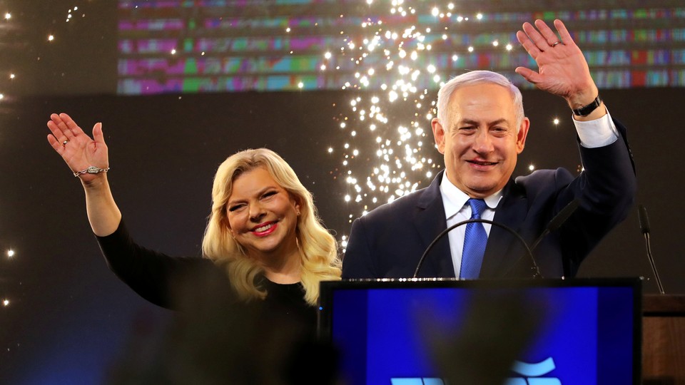 Benjamin Netanyahu and his wife, Sara, wave as Netanyahu speaks following the announcement of exit polling.
