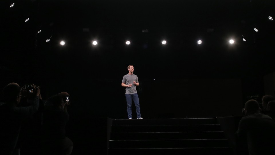 Mark Zuckerberg on a stage being photographed and lit by spotlights
