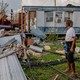 An image of a man in front of a damaged home after Hurricane Ida.