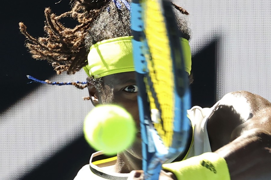 Mikael Ymer is seen forcefully striking a tennis ball.