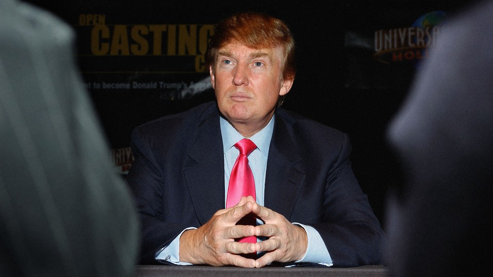 Donald Trump sits with his hands splayed and touching