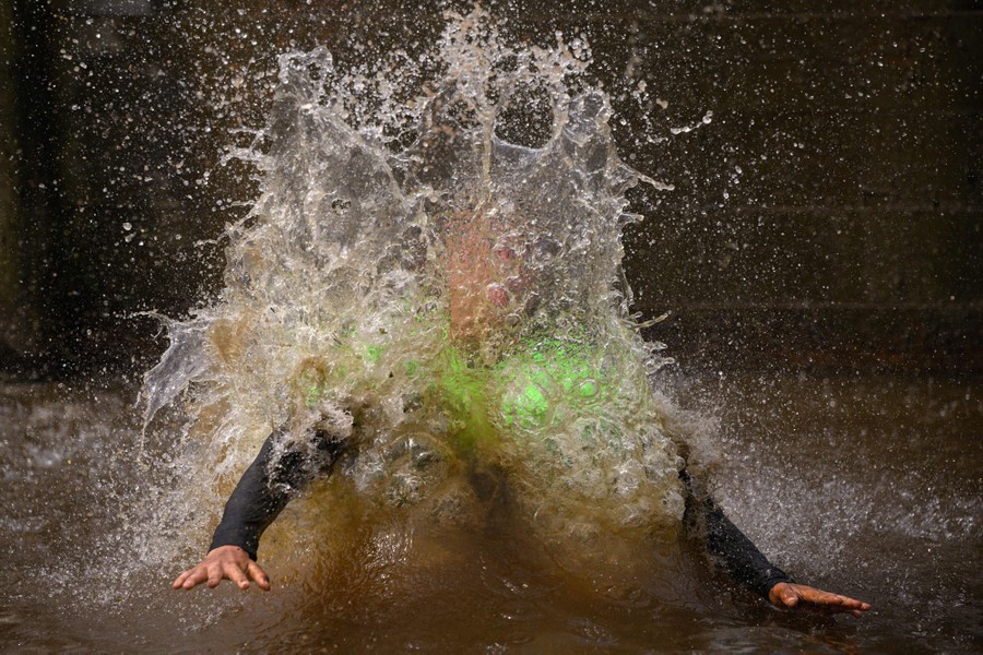 A person splashes in muddy water.