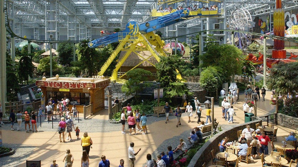 A photo showing visitors to the Mall of America, people in line to buy tickets, and a yellow-and-blue ride in the background
