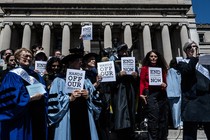 Photograph of a faculty protest at Columbia University in April, with professors holding up signs that say "Hands off our students"