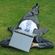 A main in a suit laying with a laptop over his head