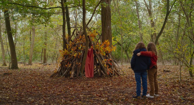 Joséphine and Gabrielle Sanz standing before a fort in the woods in "Petite Maman"