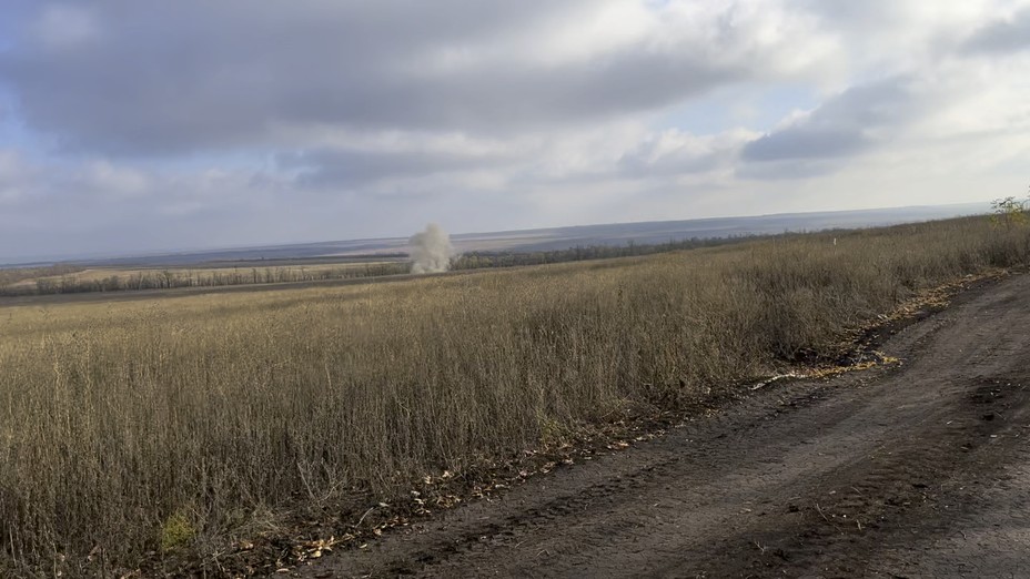 Smoke rises in the distance on a road