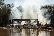 Emergency workers try to douse the smoldering remains of a banquet hall fire after the remnants of Hurricane Ida and its torrential rains tore through the area, in Manville, N.J., Sept. 3, 2021.