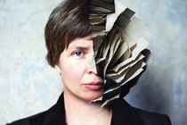 Photo-illustration with a photo of the author and half of her head replaced by torn, layered paper in a sculptural shape