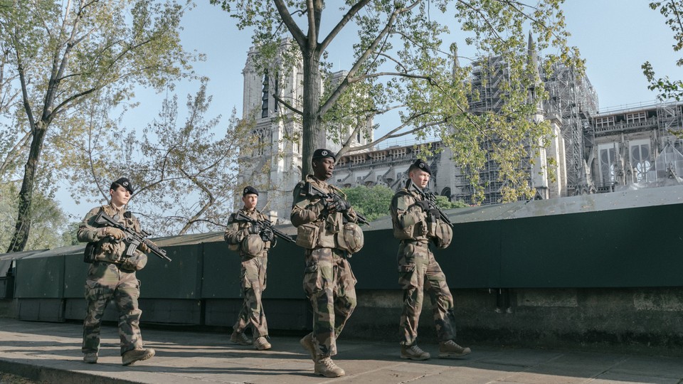 An army patrol walks along the River Seine in Paris, France.