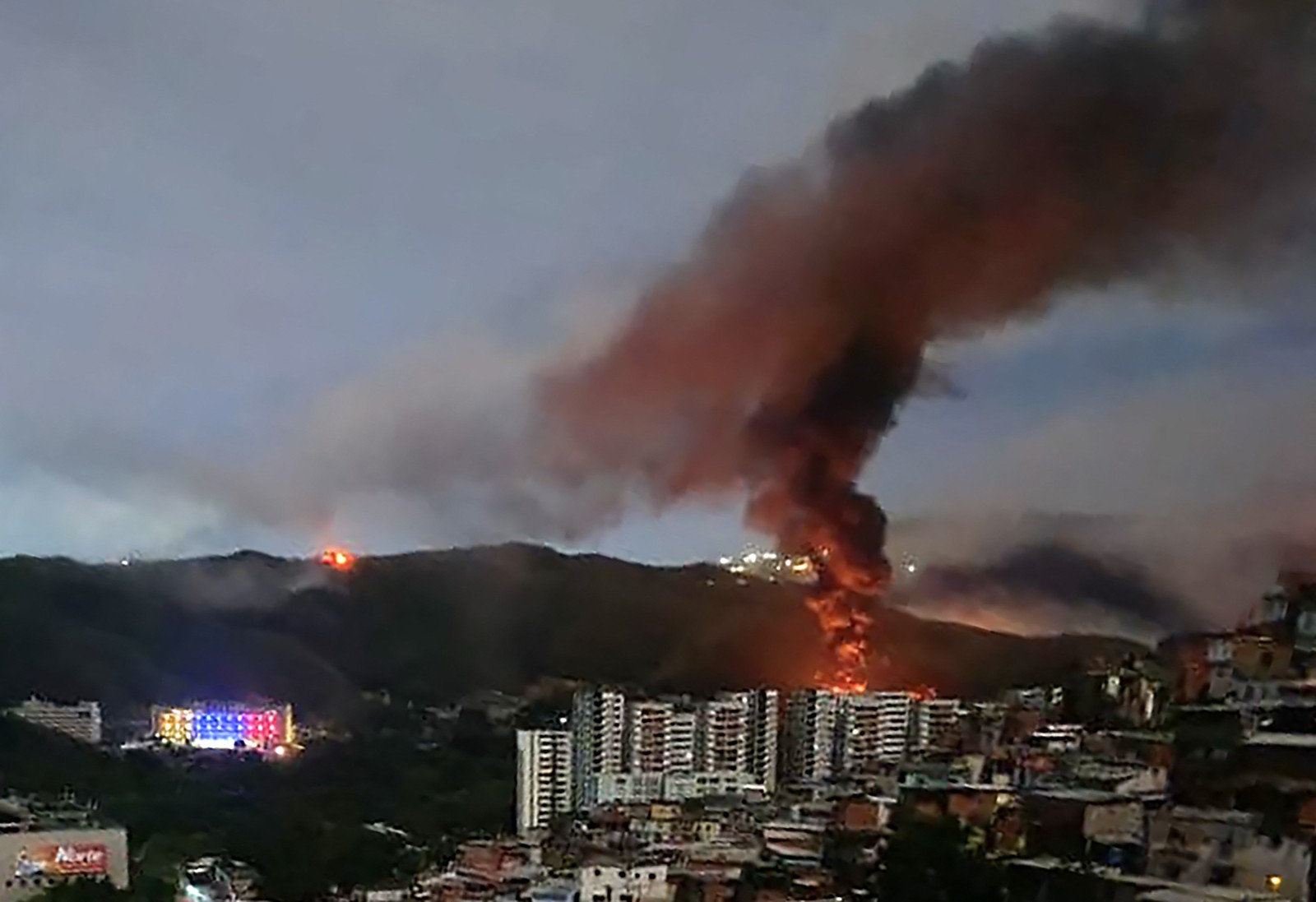 Smoke rises from a fire above buildings in a city.