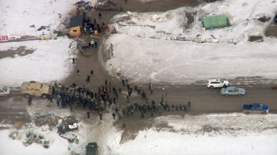 In this Wednesday, February 1, 2017, aerial image taken from a video by KXMB in Bismarck, North Dakota, law-enforcement officers line up against protesters during the eviction of about 40 Dakota Access pipeline opponents from a camp on private property owned by the pipeline developer where the protesters set up on higher ground near their flood-prone main camp. Major General Malcolm Frost said the Army was following the steps outlined in President Donald Trump's order earlier this month for a fast review of requests to approve the pipeline.