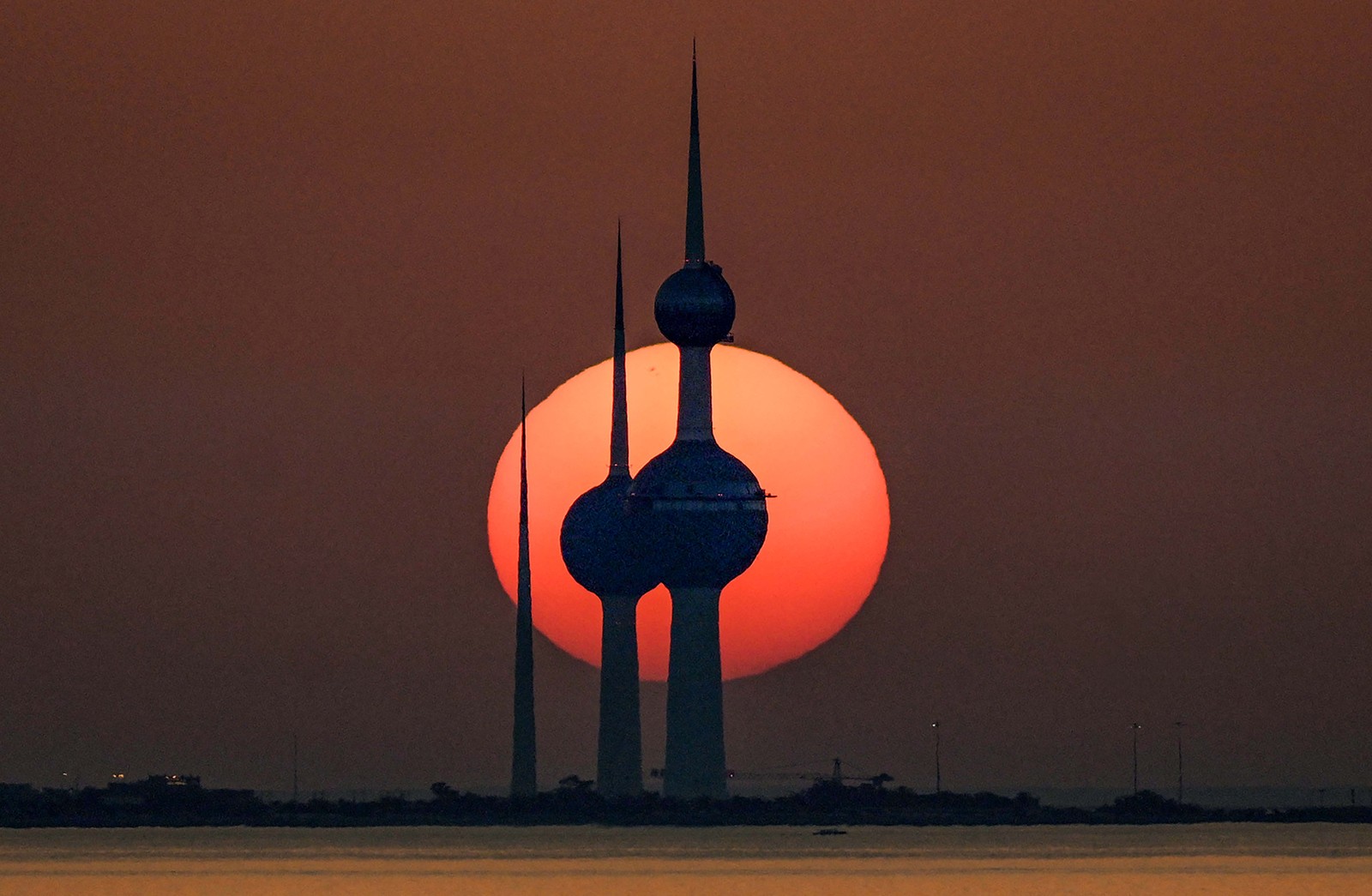 A sunset, seen beyond several tall distinctive towers