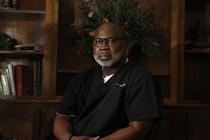 Willie Parker wears scrubs in an office.
