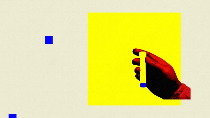 A hand holding an empty vial