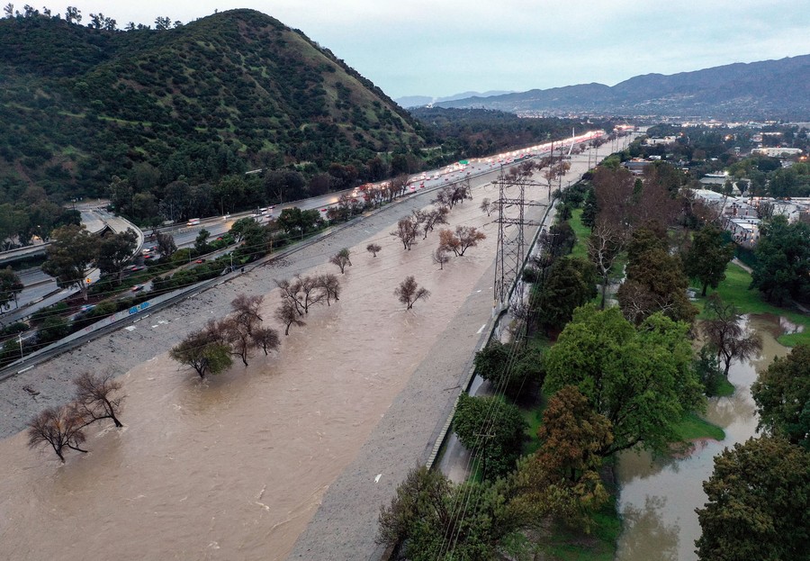 An aerial view of a river in a channel, swollen by storm runoff