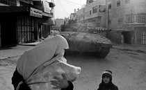 A woman and child in front of a tank