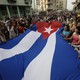Pro-government youth carry a Cuban flag in front of the Ladies in White during a protest march in Havana on March 25, 2010. 