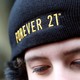 A person wearing a black Forever 21 hat