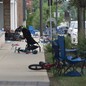 Abandoned lawn chairs and kids' bikes stand at the scene of a Fourth of July parade shooting.