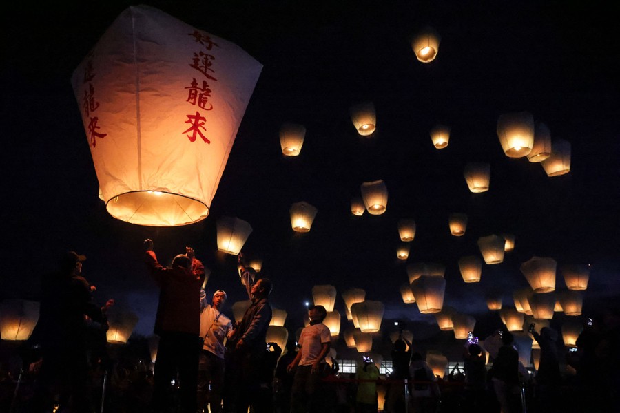 People release sky lanterns at night.