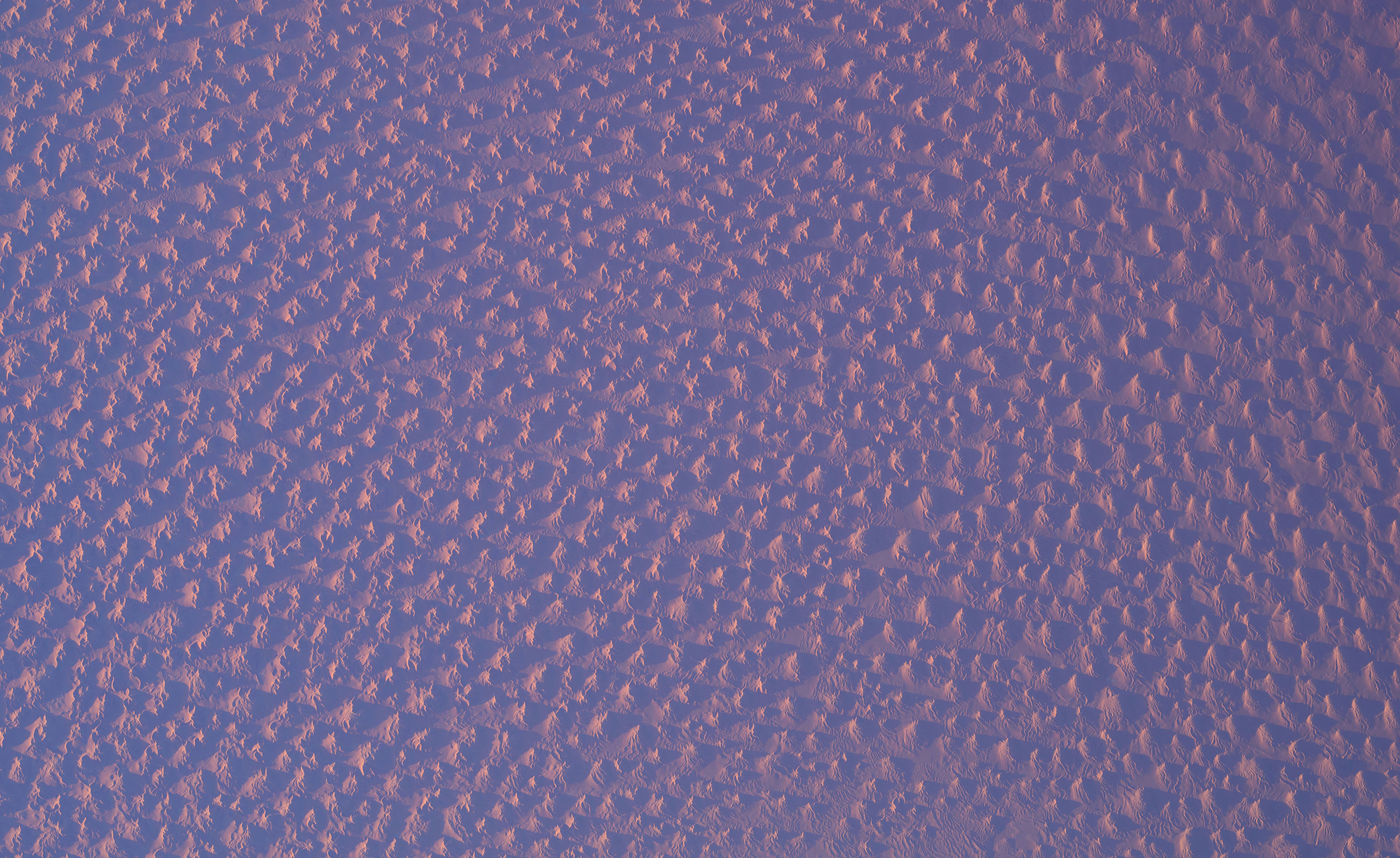 Low sunlight seen across dunes in the Sahara Desert, from high above