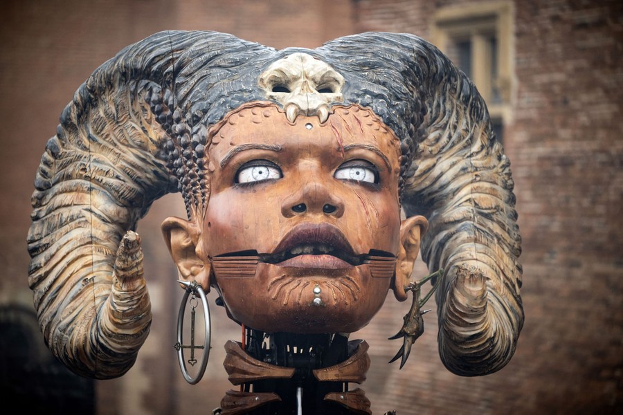 A closer view of the head of a large puppet depicting a horned mythological being.
