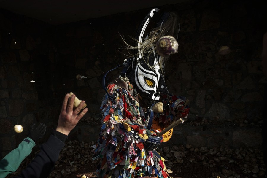 People throw turnips at the Jarramplas, a person in a colorful costume.