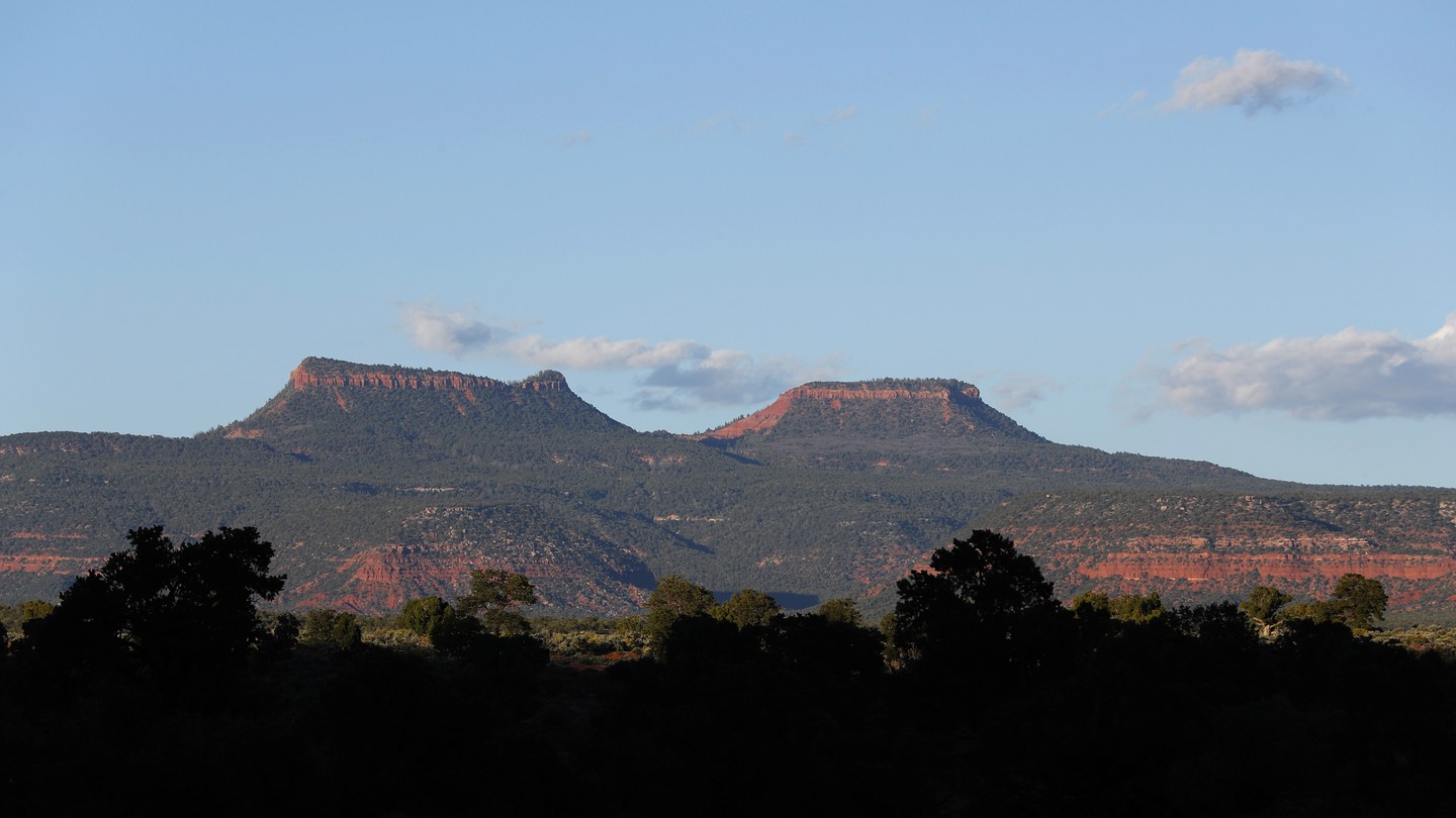 The two bluffs, known as the 'Bears Ears,' stand off in the distance at sunset in the Bears Ears National Monument