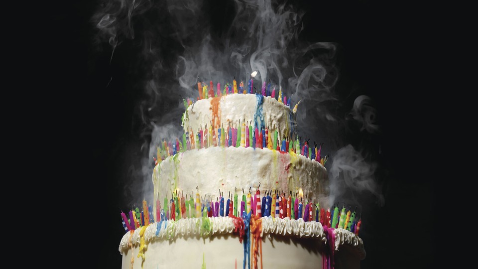 A birthday cake packed with colorful candles that have been blown out