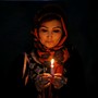 A woman holds a lit candle for the victims of Wednesday's blast in Kabul, Afghanistan.