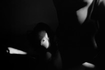 A baby's eye caught in the sunlight in mothers arms