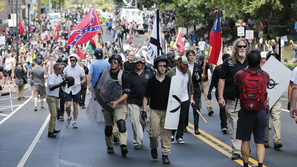White supremacists marching in Charlottesville, Virginia, on August 12, 2017, one waving a Confederate flag