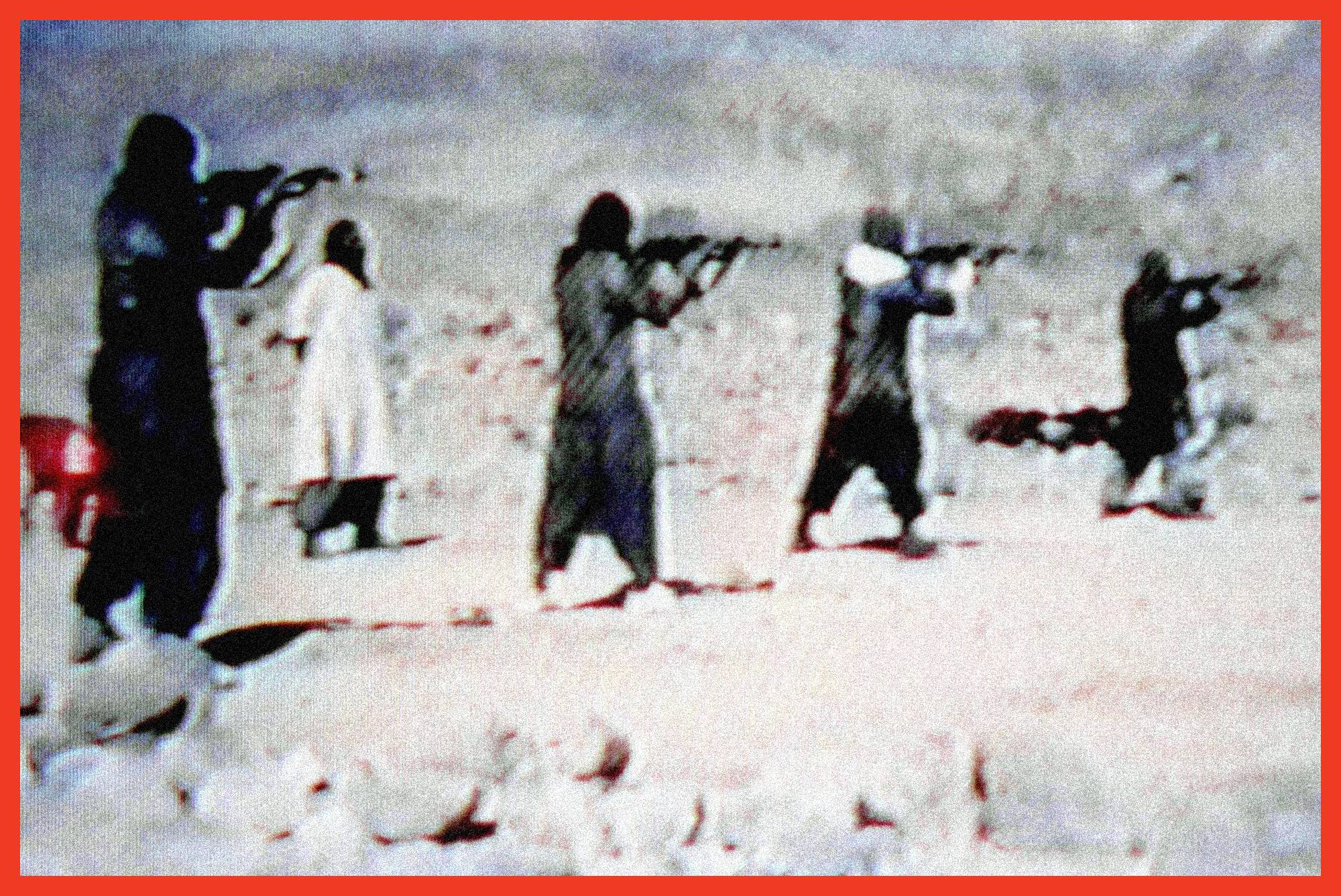 video still showing a row of hooded men firing rifles on a desert firing range