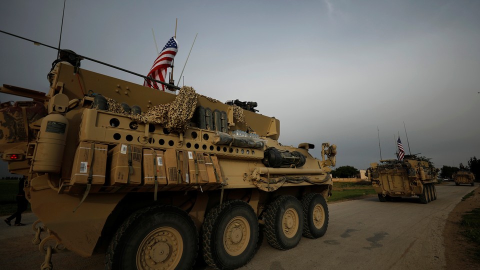 U.S. military vehicles drive in the town of Darbasiya next to the Turkish border, Syria, on April 28, 2017.