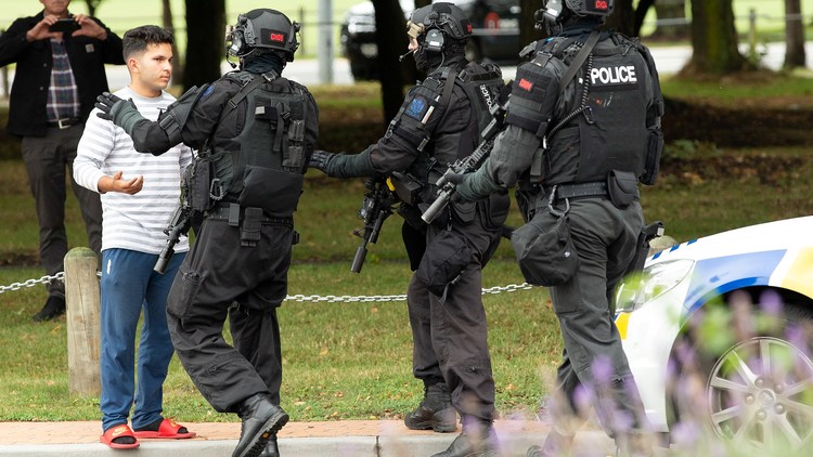 New Zealand police push back members of the public after the shooting at the Masjid Al Noor mosque in Christchurch.