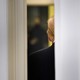 A door cracked open, with Donald Trump's back showing