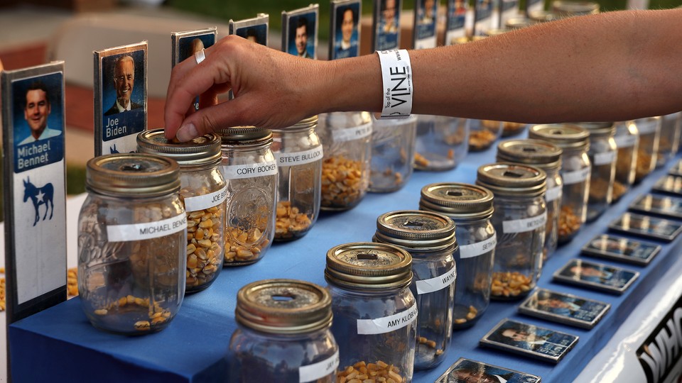 A voter drops a kernel of corn in a jar for the Iowa State Fair corn poll.