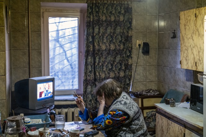 Woman a kitchen table with her head in her hands